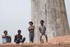 Workers and their family members standing on stacks of bricks in a brick factory where they work and stay under tough and unhealthy conditions