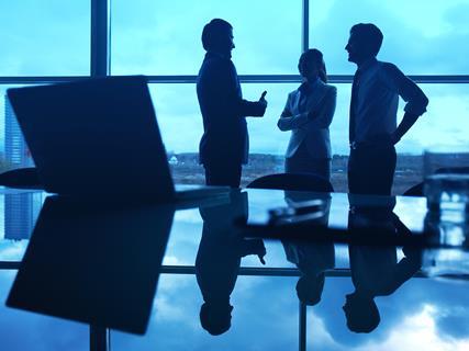 stock-photo-three-office-workers-interacting-by-the-window-with-their-workplace-in-front-162320312_CP