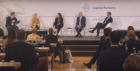 Photo of David Atkin on stage with other speakers at the Annual Investment Conference of LGT Capital Partners